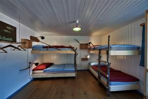 a room with three bunk beds in a house at Aktivhostel HängeMatt in Matt