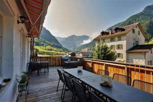 a balcony with tables and chairs and a view of mountains at Aktivhostel HängeMatt in Matt