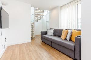 a living room with a couch and a tv at EXCEL LONDON MAJESTIC APARTMENT in London
