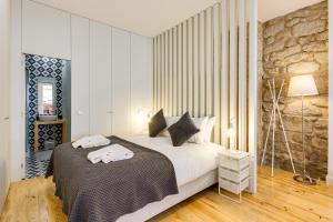 een slaapkamer met een bed met handdoeken erop bij Pinheiro Terrace Downtown Apartment by DA'HOME in Porto