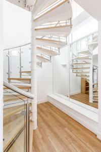 a staircase in a room with white walls and wood floors at EXCEL LONDON MAJESTIC APARTMENT in London