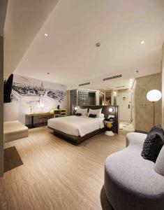 ジャカルタにあるYELLO ホテル ハーモ二のベッドとソファ付きの広いホテルルームです。
