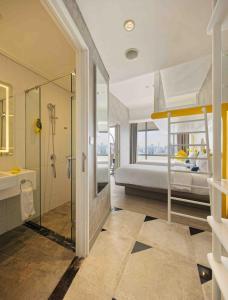a bathroom with a shower and a bed in a room at YELLO Hotel Harmoni in Jakarta