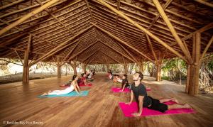 een groep mensen die yoga doen in een schuur bij Boulder Bay Eco Resort - Nga Khin Nyo Gyee Island in Nga Khin Nyo Gyee Island