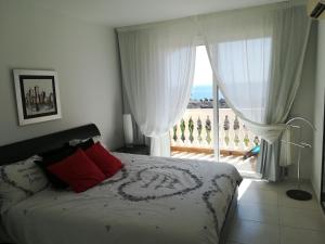sypialnia z łóżkiem i widokiem na ocean w obiekcie Parque Tropical I w mieście Los Cristianos