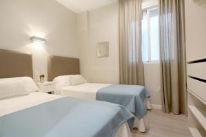 Una habitación de hotel con dos camas y una ventana. en Conde de Gondomar 1, en Córdoba