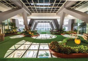 een arium van een gebouw met een grote lobby met planten bij Olympia City Hotel by Dara in Phnom Penh