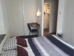 1 dormitorio con 1 cama, 1 silla y 1 mesa en Hotel Baan, en Róterdam