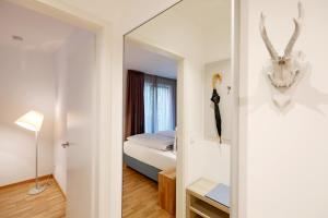 una camera da letto con un letto e uno specchio di Maximilians Domizil Edenkoben a Edenkoben