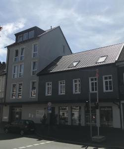 a black and white building with a car in front of it at Pension Osthoff in Wülfrath
