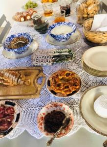 una mesa con platos y tazones de comida. en Sanbartolomeo Casa & Putìa, en Scicli