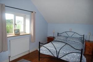 - une chambre avec un lit et une fenêtre dans l'établissement Ty Gylfinir, à Llandegla