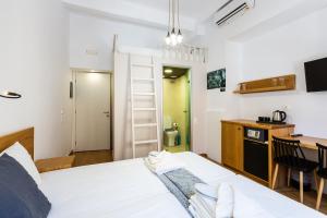 a bedroom with a bed and a kitchen with a table at Ink Hotels Phos in Rethymno