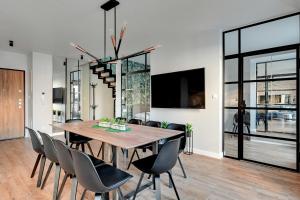 comedor con mesa de madera y sillas en Staywin Apartments en Gdansk