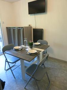einem Esstisch mit 4 Stühlen und einem TV in der Unterkunft Joli studio A front de mer in Saint-Raphaël
