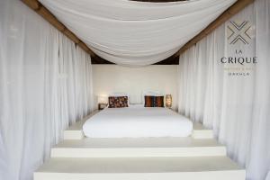 a bedroom with a white bed with white drapes at La Crique Nature & Spa in Dakhla