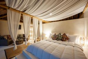 - une chambre avec un lit à baldaquin blanc dans l'établissement La Crique Nature & Spa, à Dakhla