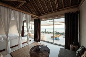 a bedroom with a bed and a large window at La Crique Nature & Spa in Dakhla