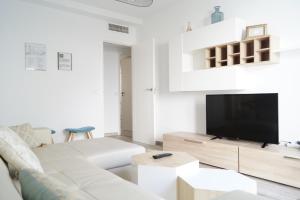sala de estar blanca con sofá blanco y TV en Apartamento Mihrab, excelente ubicacion en casco historico, en Córdoba