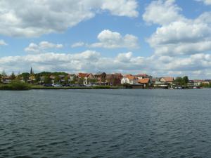 ein großer Wasserkörper mit Häusern im Hintergrund in der Unterkunft kleines Ferienhaus am Feldrand in Malchow