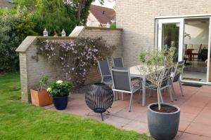 eine Terrasse mit einem Tisch und Stühlen im Hof in der Unterkunft Hello Zeeland - Vakantiehuis Zwin 092 in Breskens