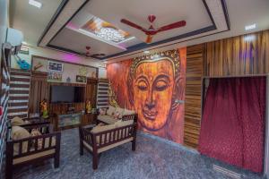 a living room with a large painting of a face on the wall at Arjun Homestay in Hampi