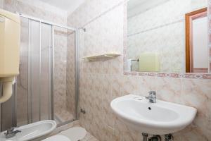 y baño con lavabo y ducha. en Hotel Al ponte, en Lignano Sabbiadoro