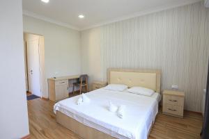 a bedroom with a large white bed with two white pillows at Hotel Botanica in Chakvi