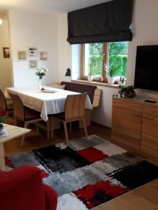 sala de estar con mesa y TV en Ferienwohnung Fichtler en Sankt Johann in Tirol