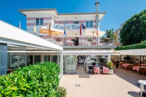 a building with a patio with tables and chairs at Hotel Al ponte in Lignano Sabbiadoro