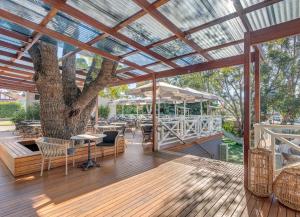 a patio with a tree and a table and chairs at Wentworth Hotel in Sydney