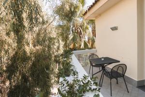 a patio with a table and chairs and trees at Sicilia's Art Hotel & Spa in Acitrezza