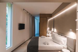 a hotel room with a bed and a window at Sicilia's Art Hotel & Spa in Acitrezza