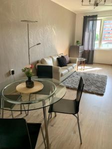 ein Wohnzimmer mit einem Glastisch und einem Sofa in der Unterkunft Apartman Skupovka in Most