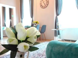 uma sala de estar com um vaso cheio de flores brancas em Budapest Palace Apartment - Palace District - Downtown em Budapeste