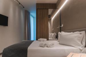 a hotel room with a bed with towels on it at Sicilia's Art Hotel & Spa in Acitrezza