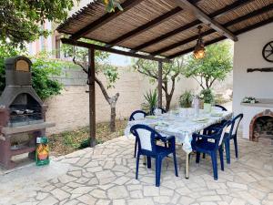 a patio with a table and chairs and an outdoor oven at Villa Bianca Kunstmann in Orosei