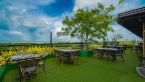 a row of tables and chairs on the grass at Sasha Transit Hotel in Katunayake