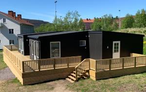 a house with a large deck and a black at Private Chalet with Sauna in Kiruna