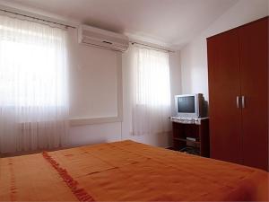 een slaapkamer met een bed en een televisie. bij Bastinac 2 in Veli Lošinj