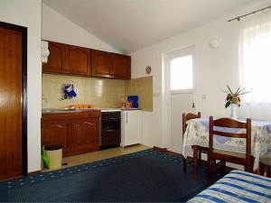 een keuken met een tafel en een eetkamer bij Bastinac 2 in Veli Lošinj