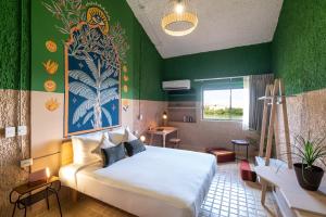 - une chambre avec un lit et un mur vert dans l'établissement Selina Cancun Laguna Hotel Zone, à Cancún