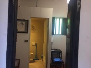 a hallway with a room with a toilet and a chair at 來喜樓-珠山82號民宿 in Jincheng