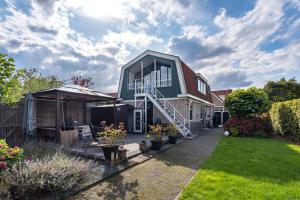 une maison avec un toit vert et une cour dans l'établissement Amsterdam Countryside met Airco , luxe keuken en een geweldig uitzicht, Immer besser!, à Den Ilp