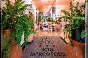 un cartel de hotel marco polo en una habitación con plantas en Hotel Marco Polo, en Lignano Sabbiadoro