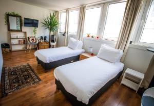 two beds in a room with two windows at City Break Amsterdam in Amsterdam +15 photos