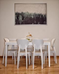 a dining room with a white table and chairs at Ypsibloom in Castelbuono