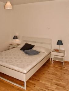 a bedroom with a white bed with two night stands at Ypsibloom in Castelbuono