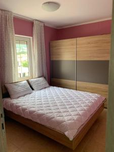 um quarto com uma cama e uma janela em Appartment Ajkunic em Sutomore