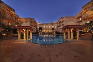 une grande cour avec une piscine ouverte la nuit dans l'établissement Taj Hari Mahal Jodhpur, à Jodhpur